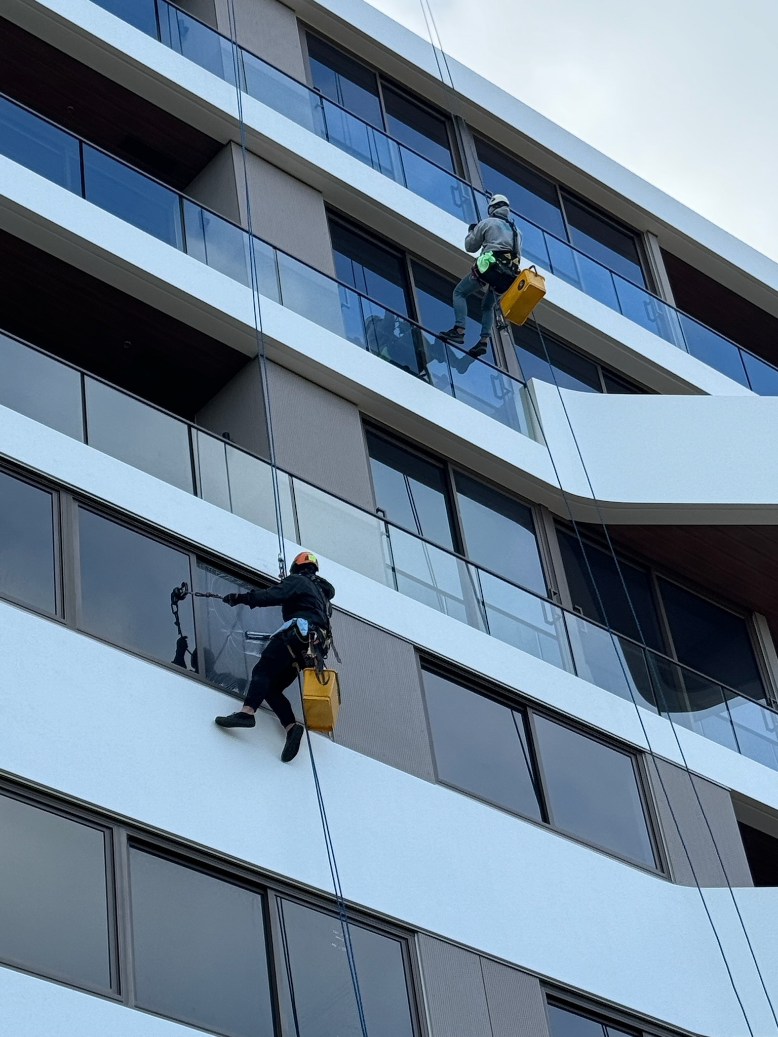 Rope access technician preparing ropes and harness at the top of a Sydney building